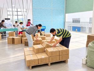 Packing a finished inflatable product into a shipping carton at the COMCO factory